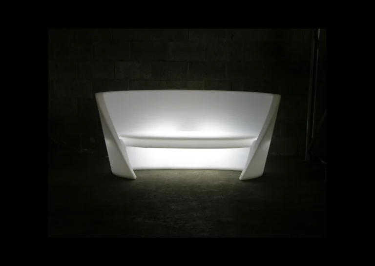 Sofa Rap lumineux en blanc, éclairé de l'intérieur et photographié dans une pièce sombre. Ce canapé au design moderne, disponible à la location chez PSB Lounge, crée une ambiance élégante et contemporaine idéale pour des événements en soirée ou des espaces lounge. Son rétroéclairage apporte une touche sophistiquée qui attire l'œil dans tout espace événementiel.