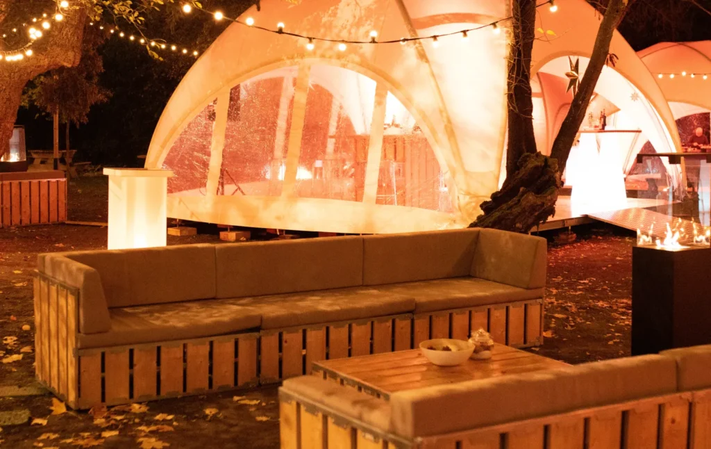 Salon lounge en bois éclairé en soirée devant un dôme, mobilier PSB Lounge