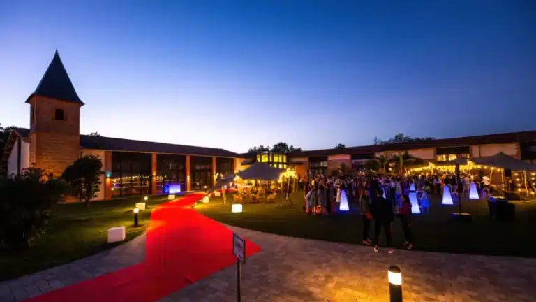 Tapis rouge et mobilier lumineux à la tombée du jour devant le Domaine de Preissac, soirée de remise de diplômes