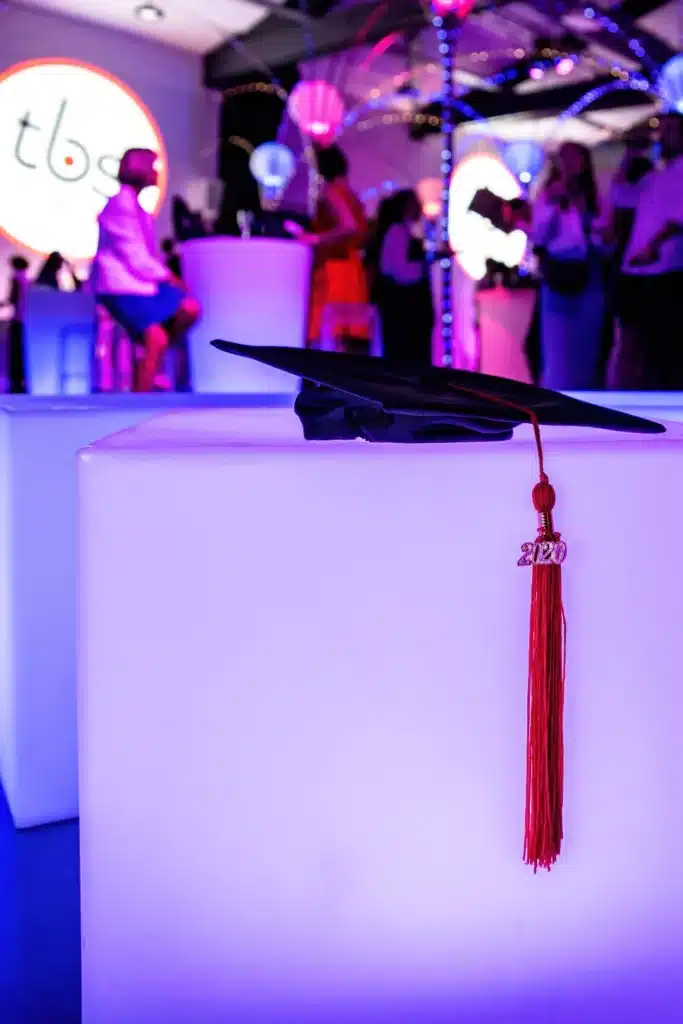 Toque de diplômé posée sur un cube lumineux blanc, soirée de remise de diplômes