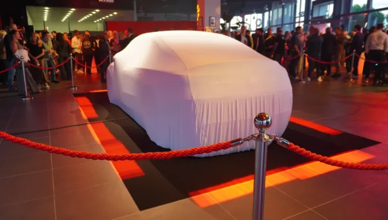 Véhicule caché sous une housse blanche avant la révélation, lors d’un lancement de produit