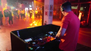 DJ derrière sa régie dans une salle en éclairage rouge