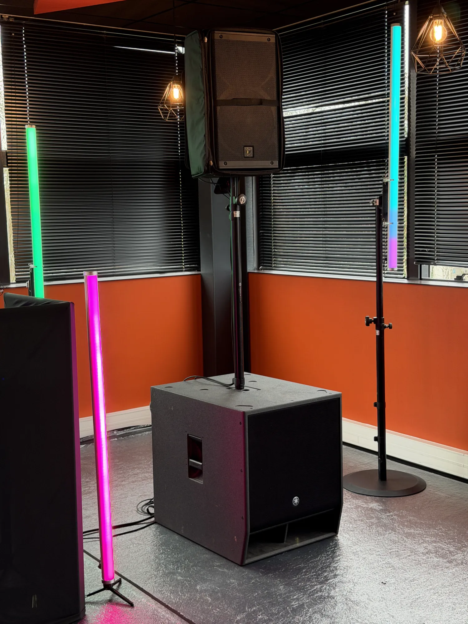 Caisson de basses et tubes lumineux colorés installés dans une salle