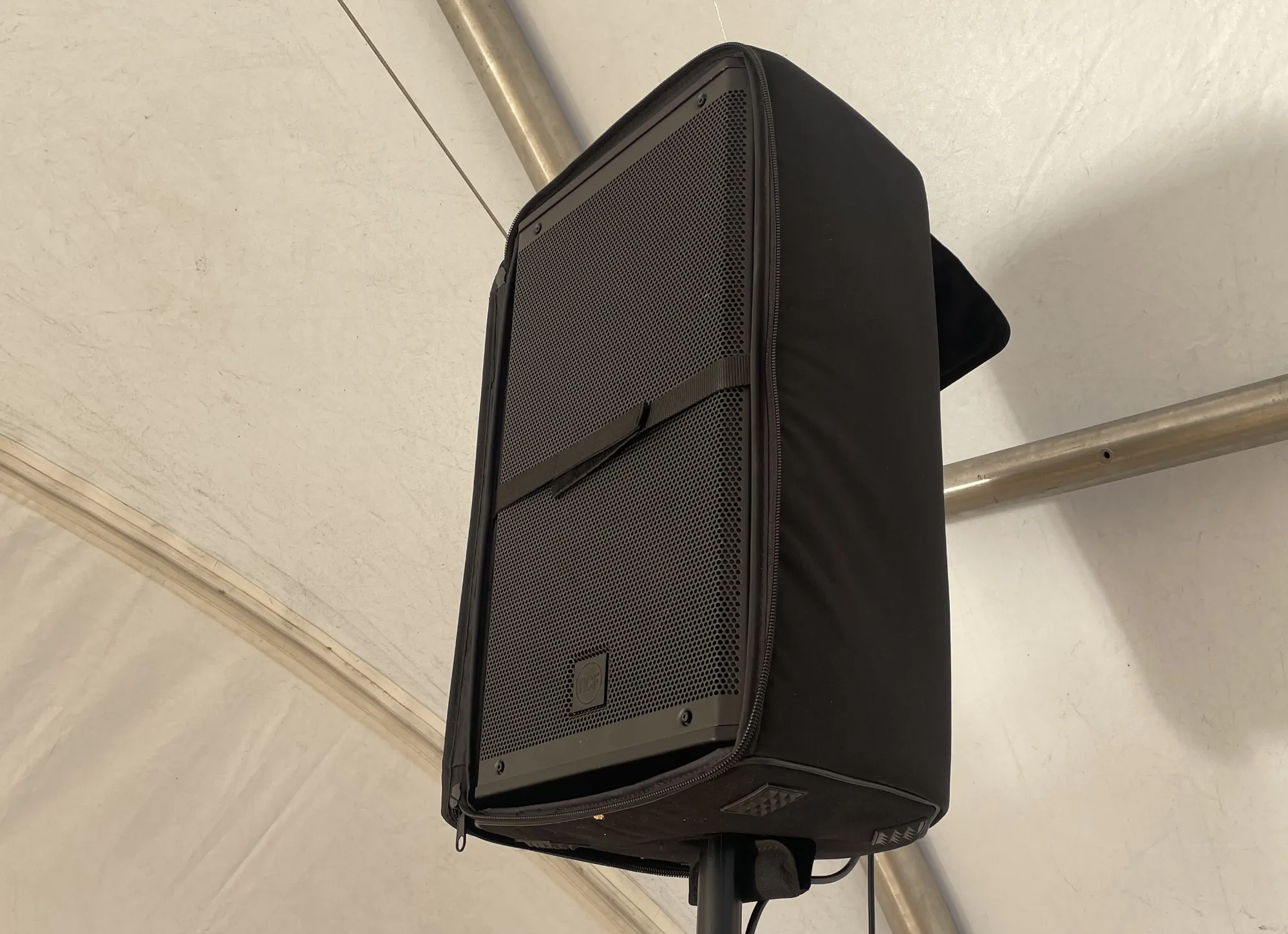 Enceinte de sonorisation sur pied sous une structure toilée blanche