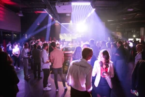 Soirée d’entreprise en concession automobile, invités sous des faisceaux lumineux, production PSB Lounge