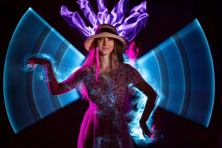 Artiste en costume lumineux devant un décor de faisceaux bleus