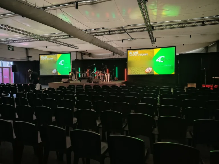 Salle de plénière installée pour une convention d’entreprise au Stade Toulousain, chaises en rangs face à la scène