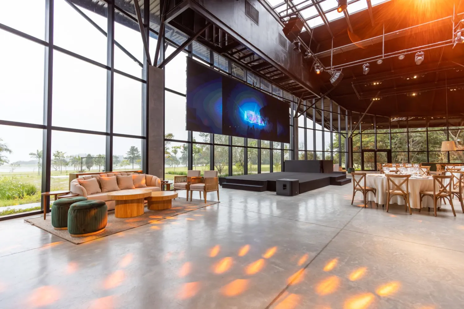 Écran LED installé dans une salle événementielle vitrée, en lumière du jour