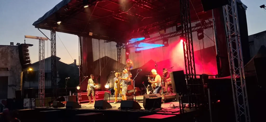Concert sur scène mobile avec éclairage scénique bleu et rouge à la tombée de la nuit