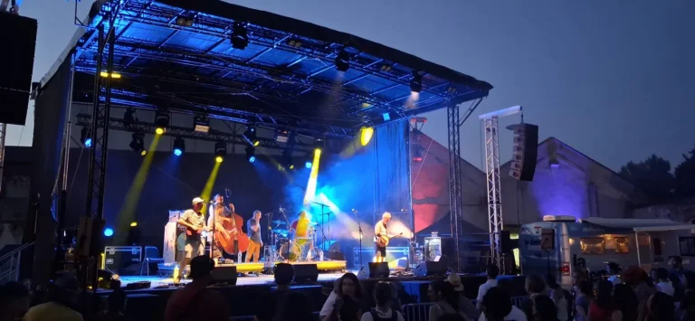 Scène mobile de festival éclairée en contre-jour bleu et faisceaux dorés