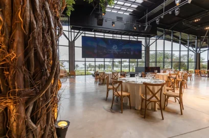Écran géant en fond d'une salle de réception aux tables dressées