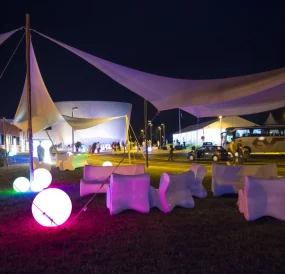 Espace lounge extérieur de nuit sous toile tendue, assises lumineuses PSB Lounge
